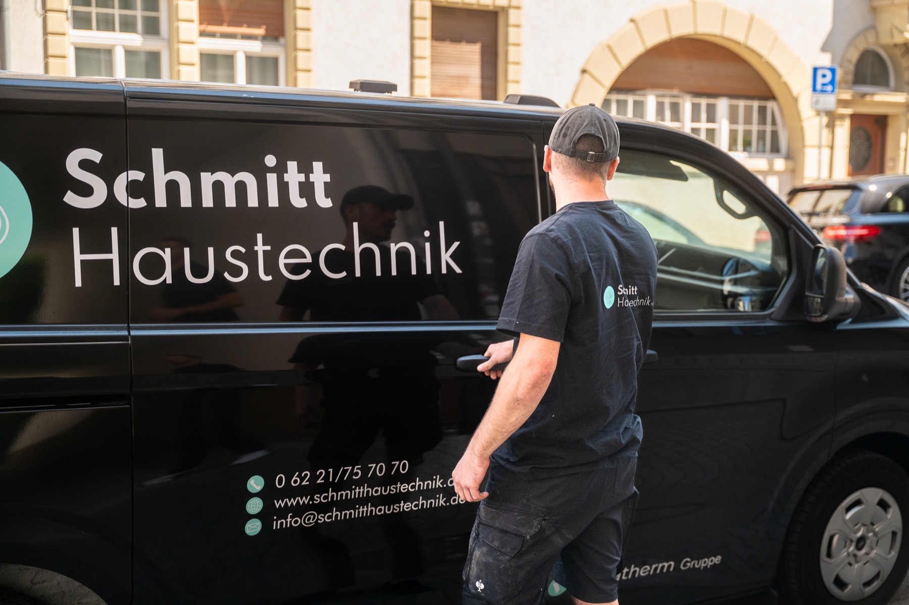 SHK-Monteur vor seinem Servicefahrzeug auf dem Weg zum nächsten Einsatz